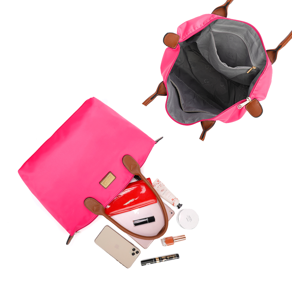 Eine pinke Tasche ist geöffnet und zeigt den Inhalt, wie ein Telefon und Make-up. Eine andere Tasche ist links.