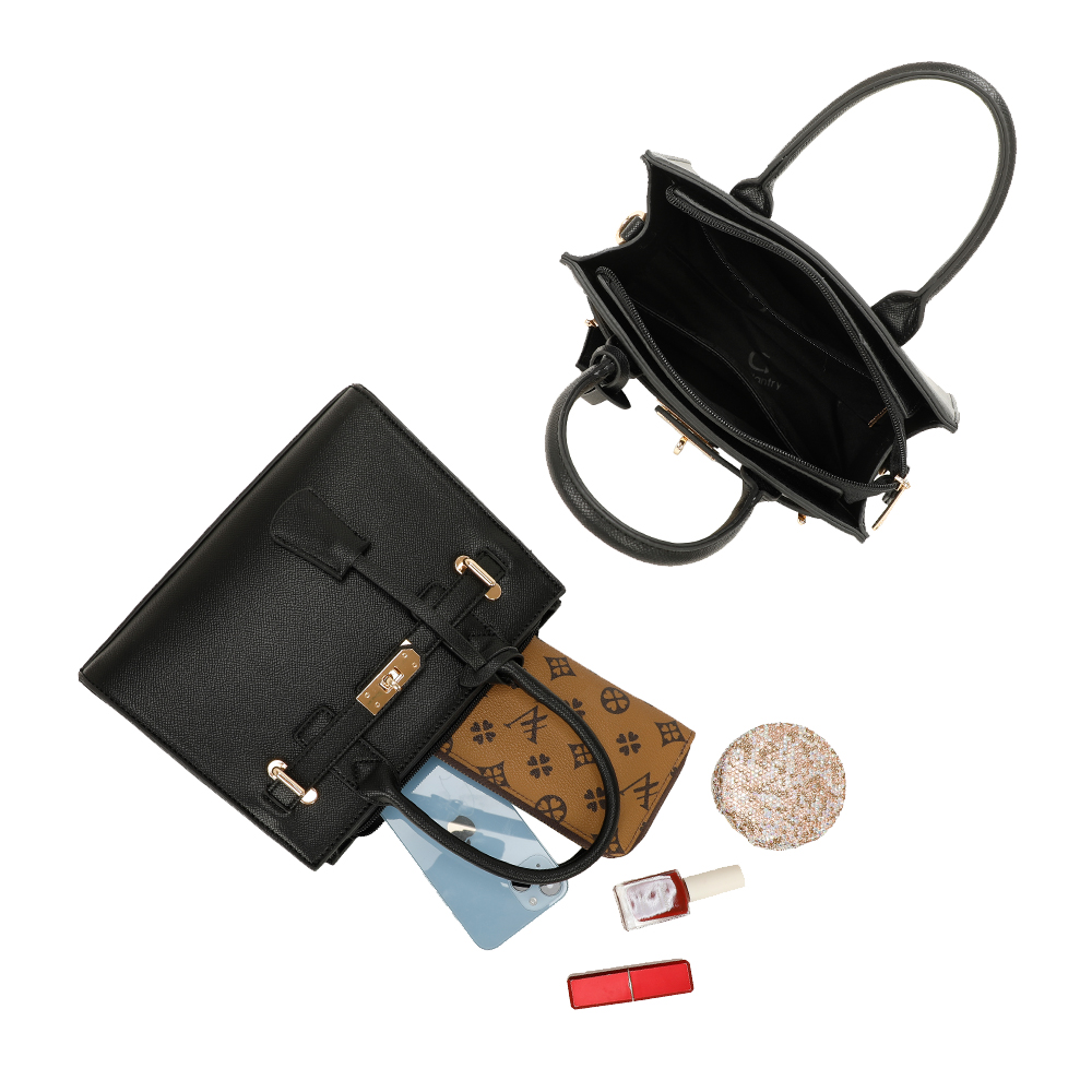 Draufsicht auf eine schwarze Handtasche mit herausfallendem Inhalt, einschließlich Telefon und Lippenstift.