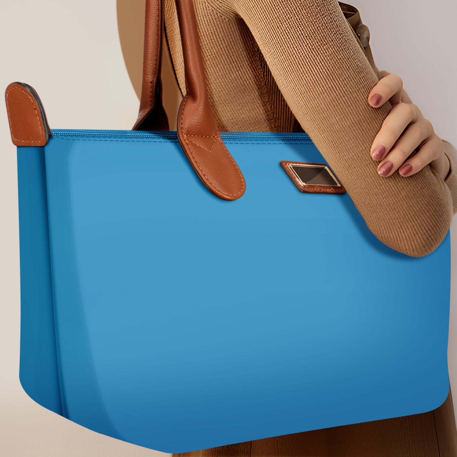 Eine blaue Tragetasche mit braunen Ledergriffen, gehalten von einem Arm.