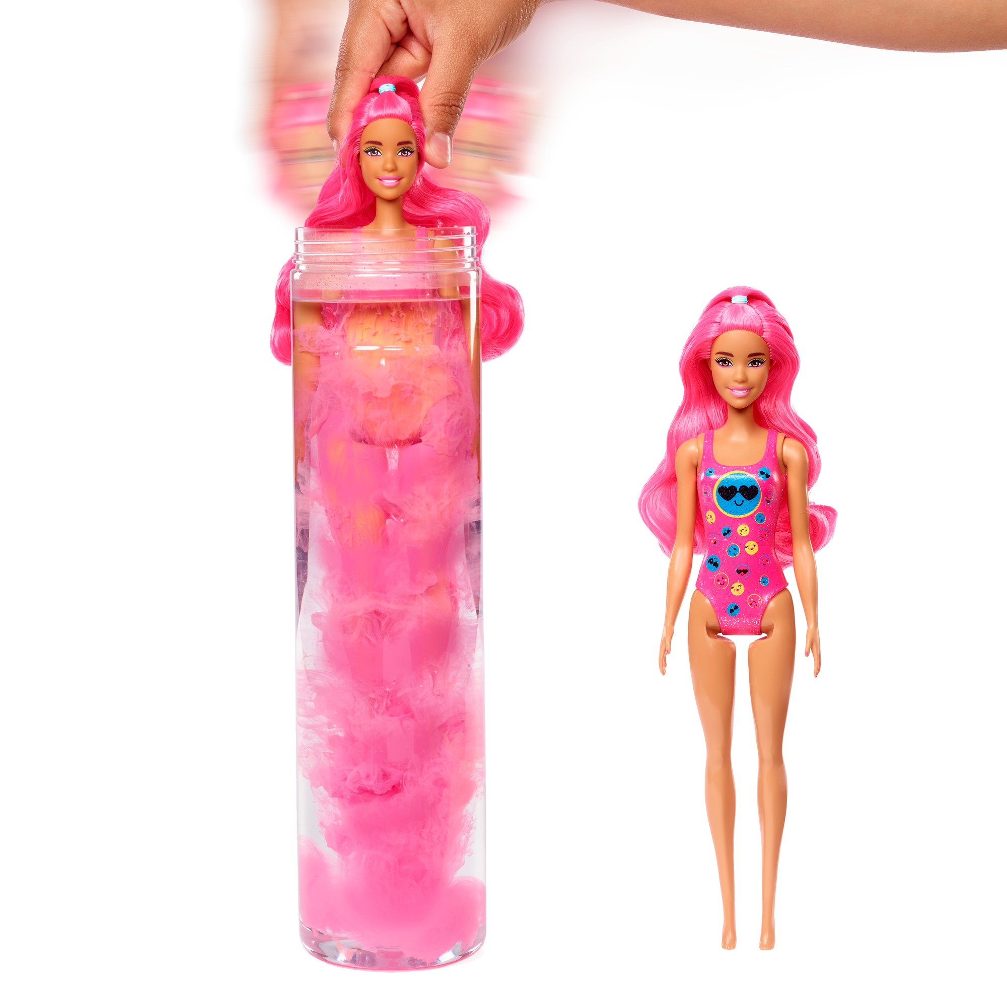 Eine Barbie-Puppe wird aus einer rosa Wolke in einer durchsichtigen Röhre enthüllt, eine andere Puppe steht daneben.