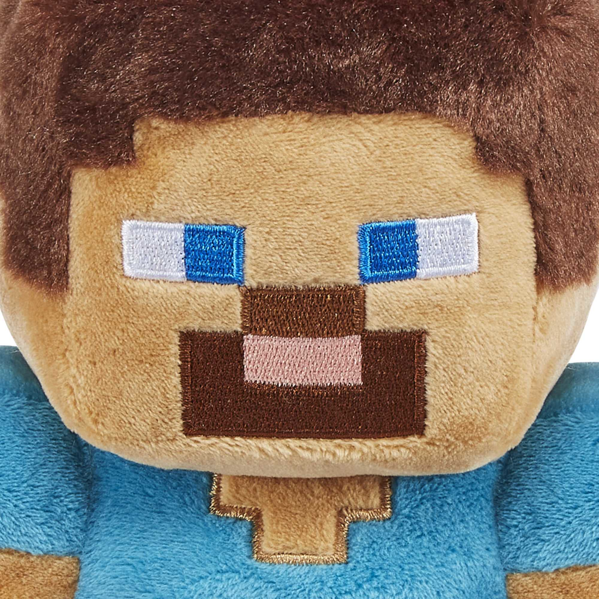 Nahaufnahme eines Minecraft Steve-Kopfes aus Plüsch, mit quadratischen Merkmalen und blauen und braunen Details.