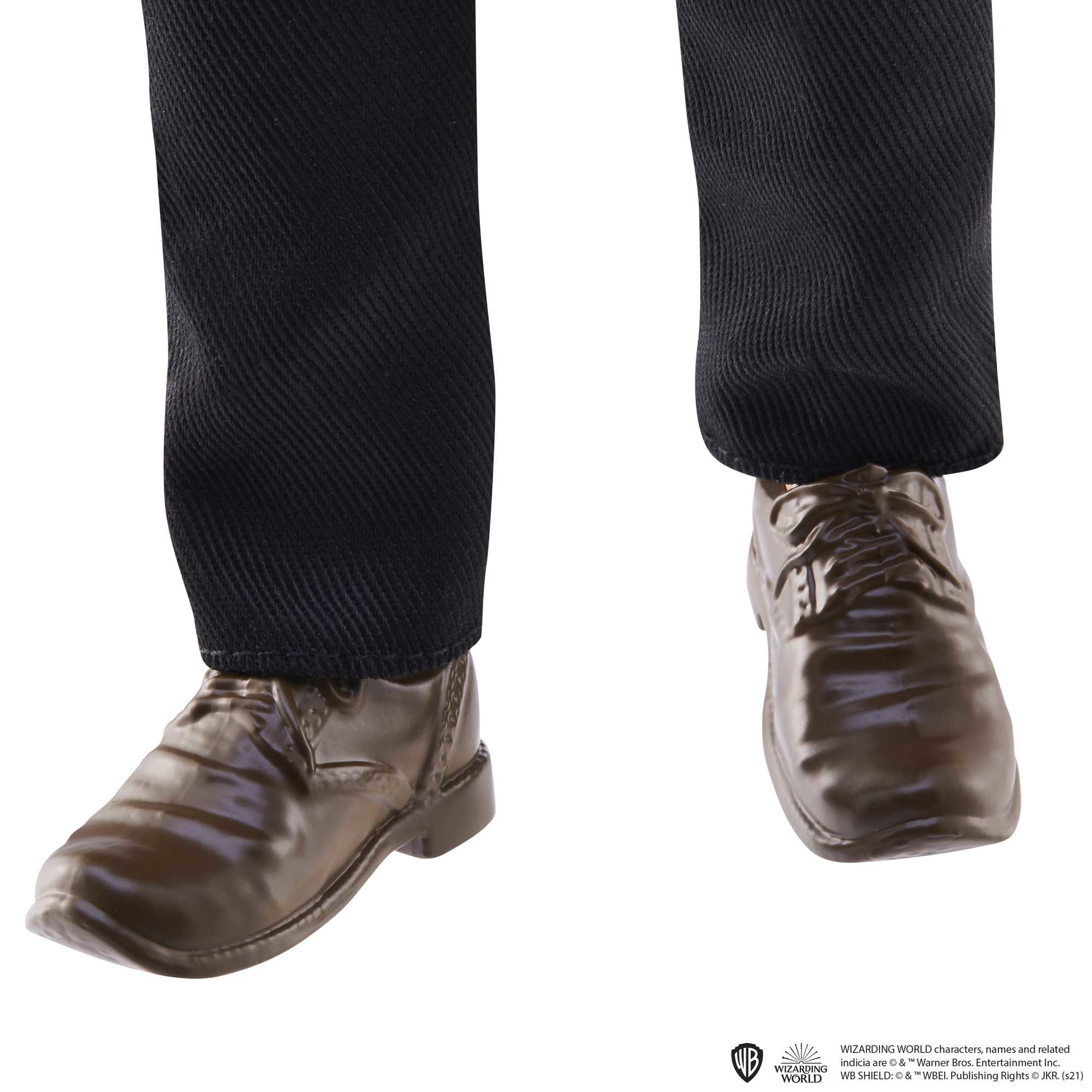 Dolna część nóg i stóp w czarnych spodniach i brązowych butach.