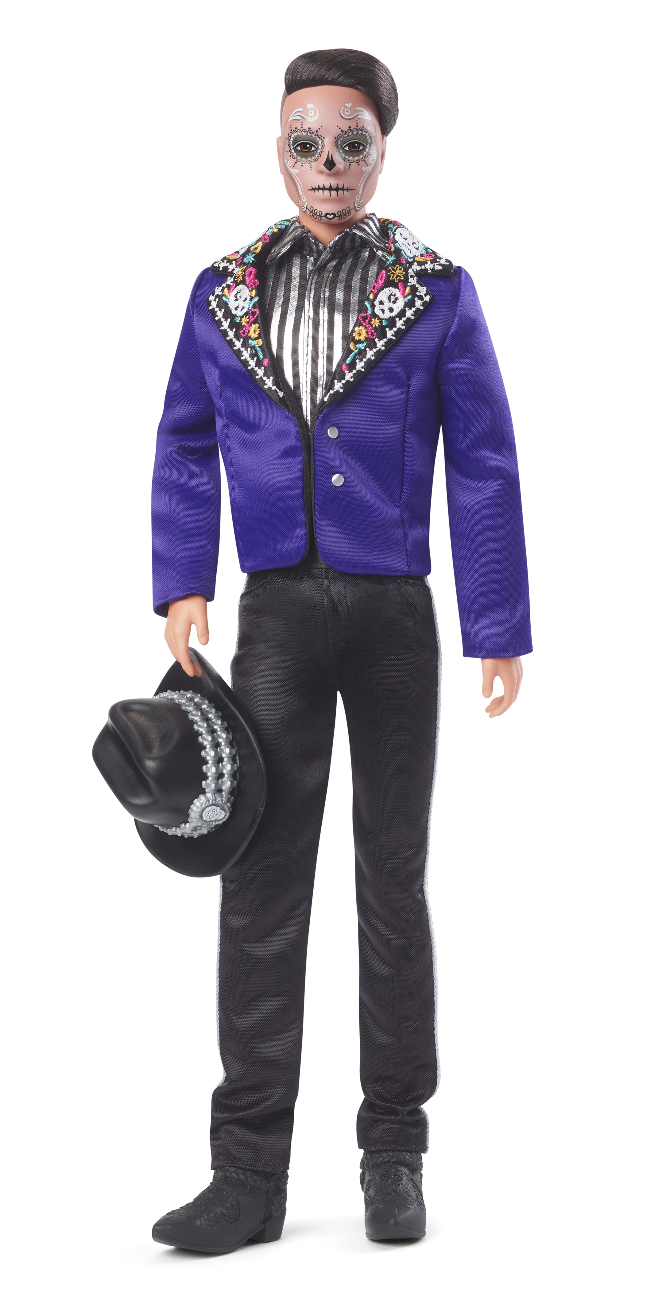 Lalka Barbie w tradycyjnym kostiumie Dia de Muertos, trzymająca kapelusz. Twarz pomalowana.