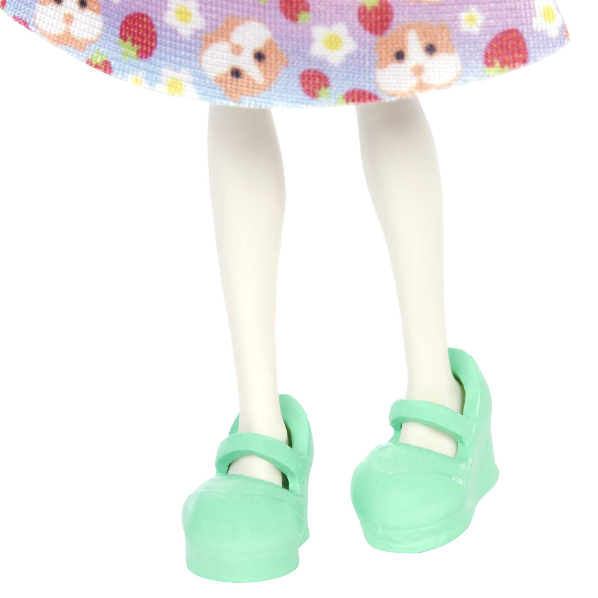 Nogi lalki z miętowo-zielonymi butami i widoczną sukienką w wzory.
