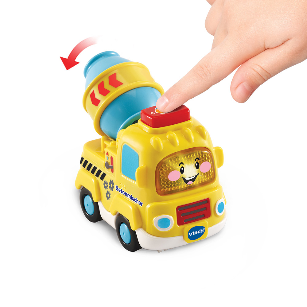 Die Hand eines Kindes drückt einen Knopf auf einem gelben Spielzeug-Zementmischwagen. Es hat ein lächelndes Gesicht.