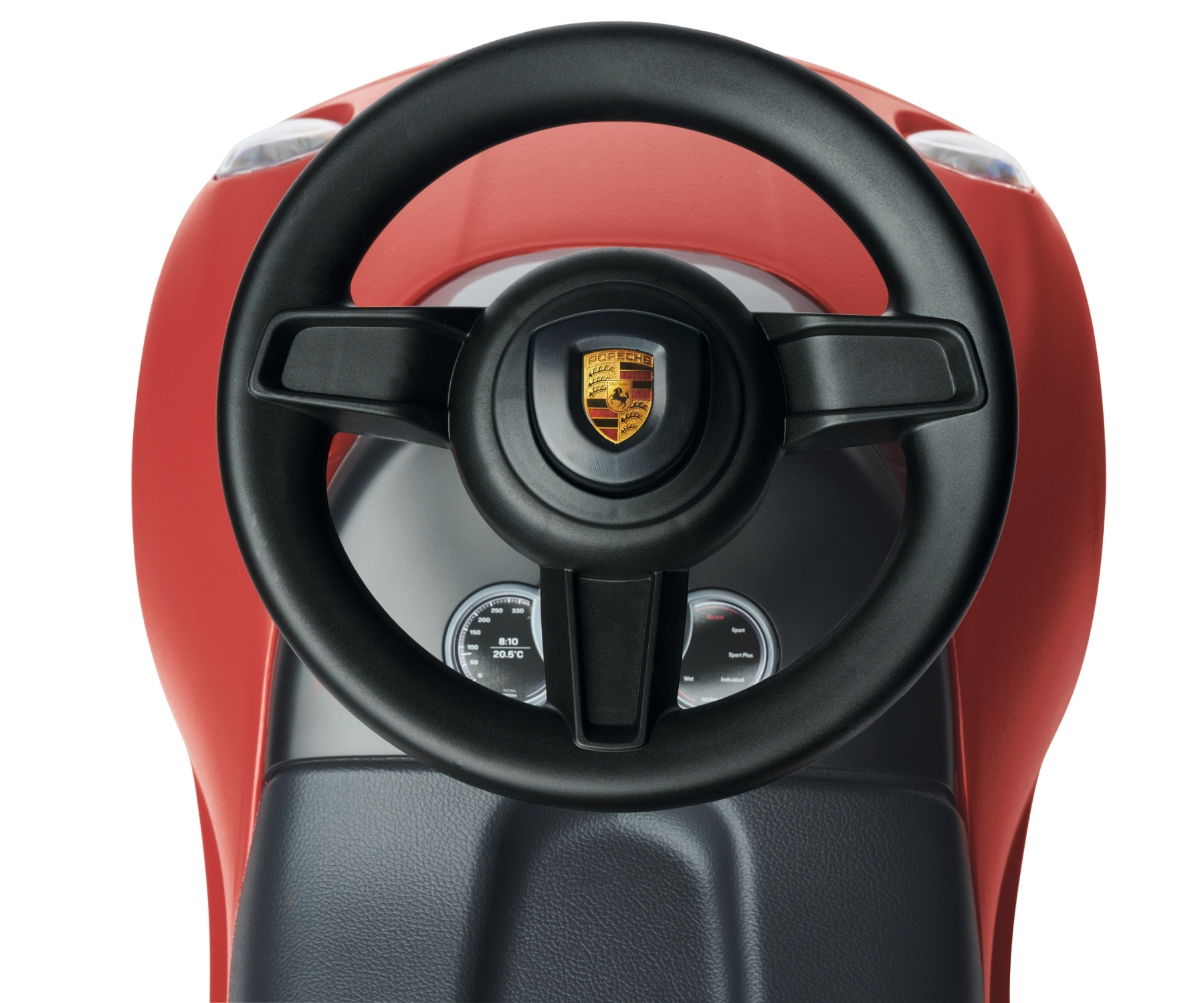 Nahaufnahme des Armaturenbretts eines roten Spielzeugautos, das ein Lenkrad mit einem Porsche-Emblem zeigt.
