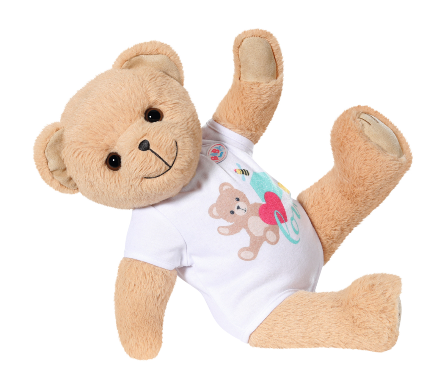 Ein beigefarbener Teddybär mit einem Hemd mit einem Teddybären und einem Herz darauf. Der Bär ist in der Luft, ein Bein hoch.