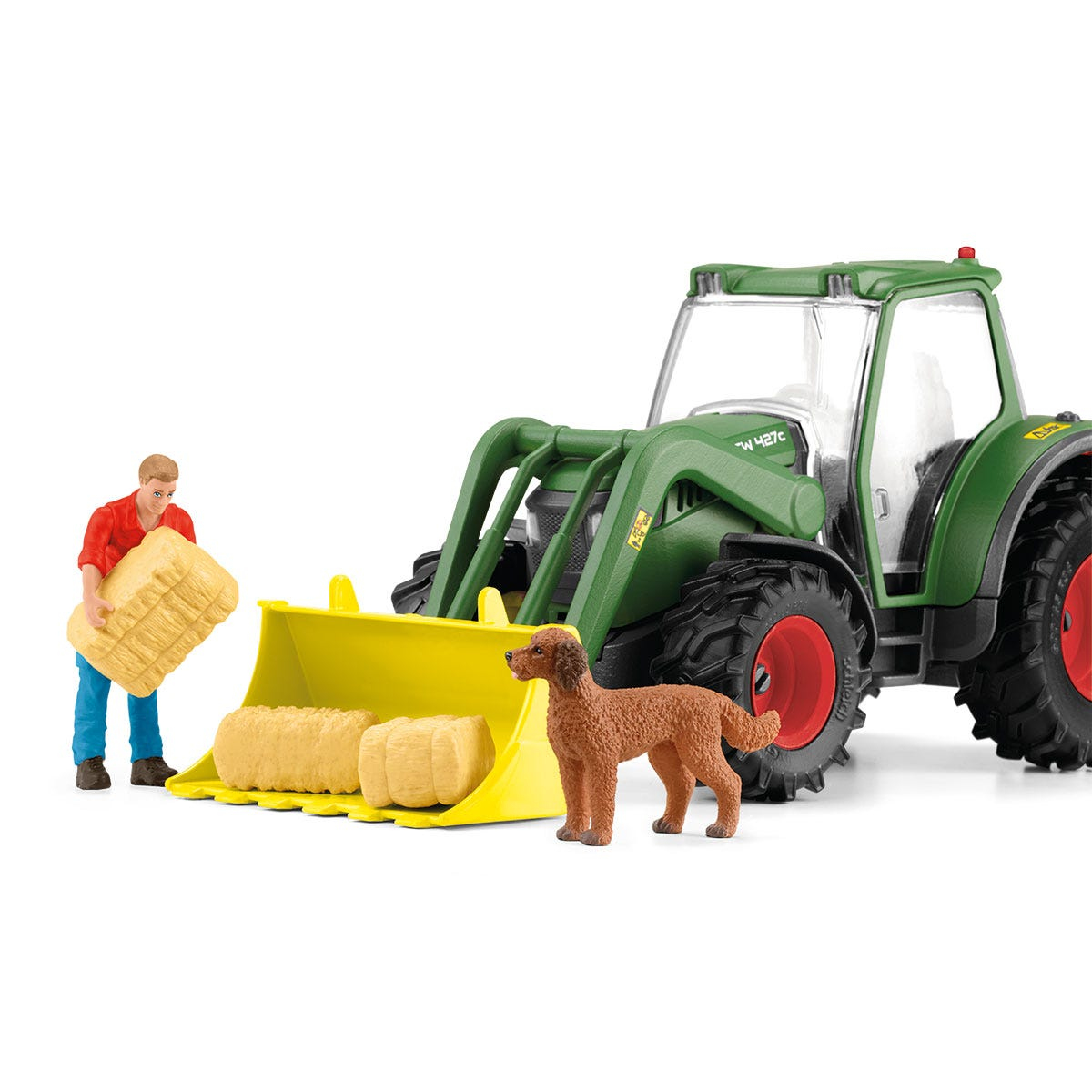 Ein grüner Traktor mit gelbem Frontlader, eine Person, die Heuballen lädt, und ein brauner Hund.