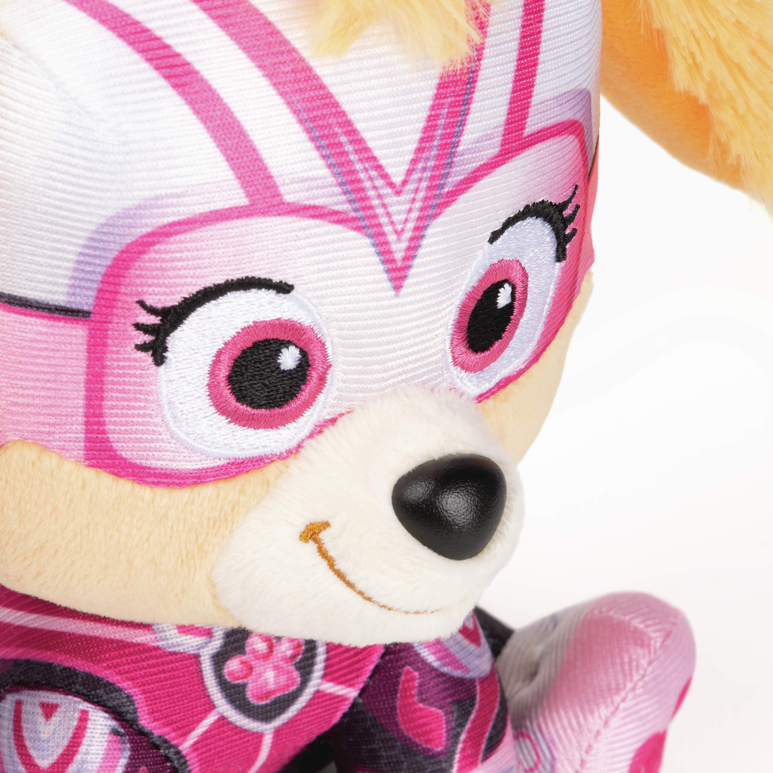 Nahaufnahme eines rosa, weißen und schwarzen Plüschtiers. Das Spielzeug hat eine rosa Superheldenmaske.