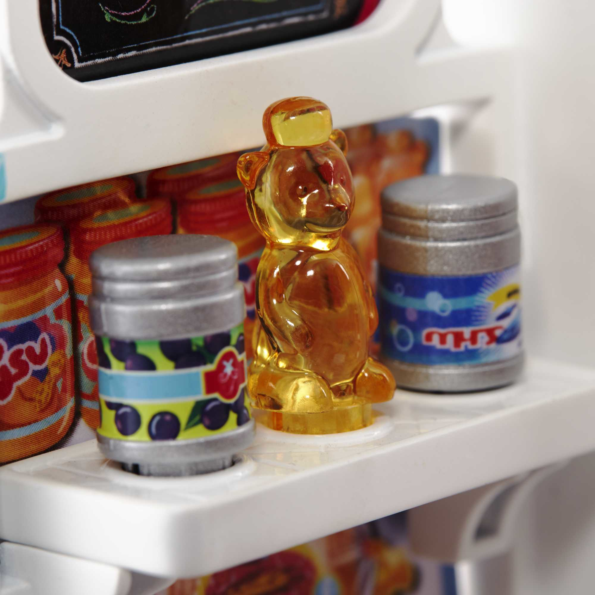 Zbliżenie półki z zabawkami z konserwami i pojemnikiem w kształcie misia miodu.
