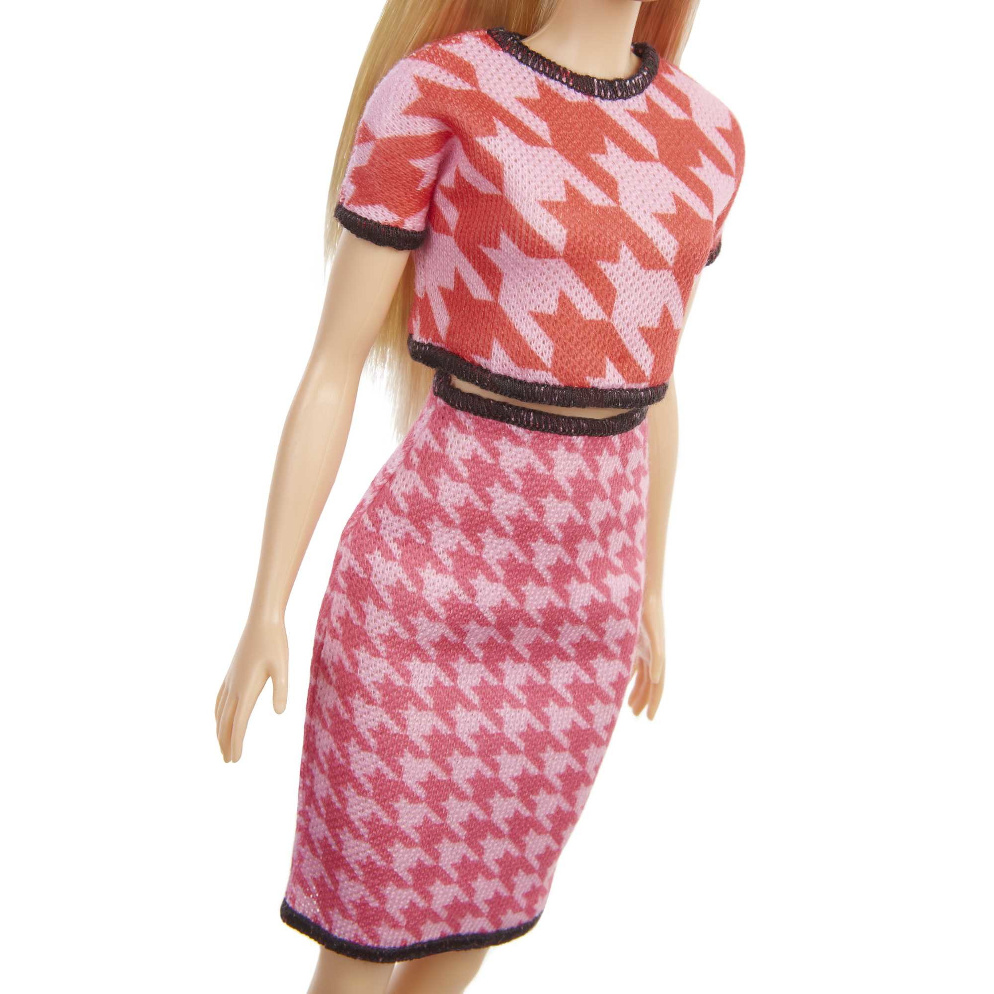 Una muñeca Barbie con una falda y un top con estampado de pata de gallo rosa y rojo.
