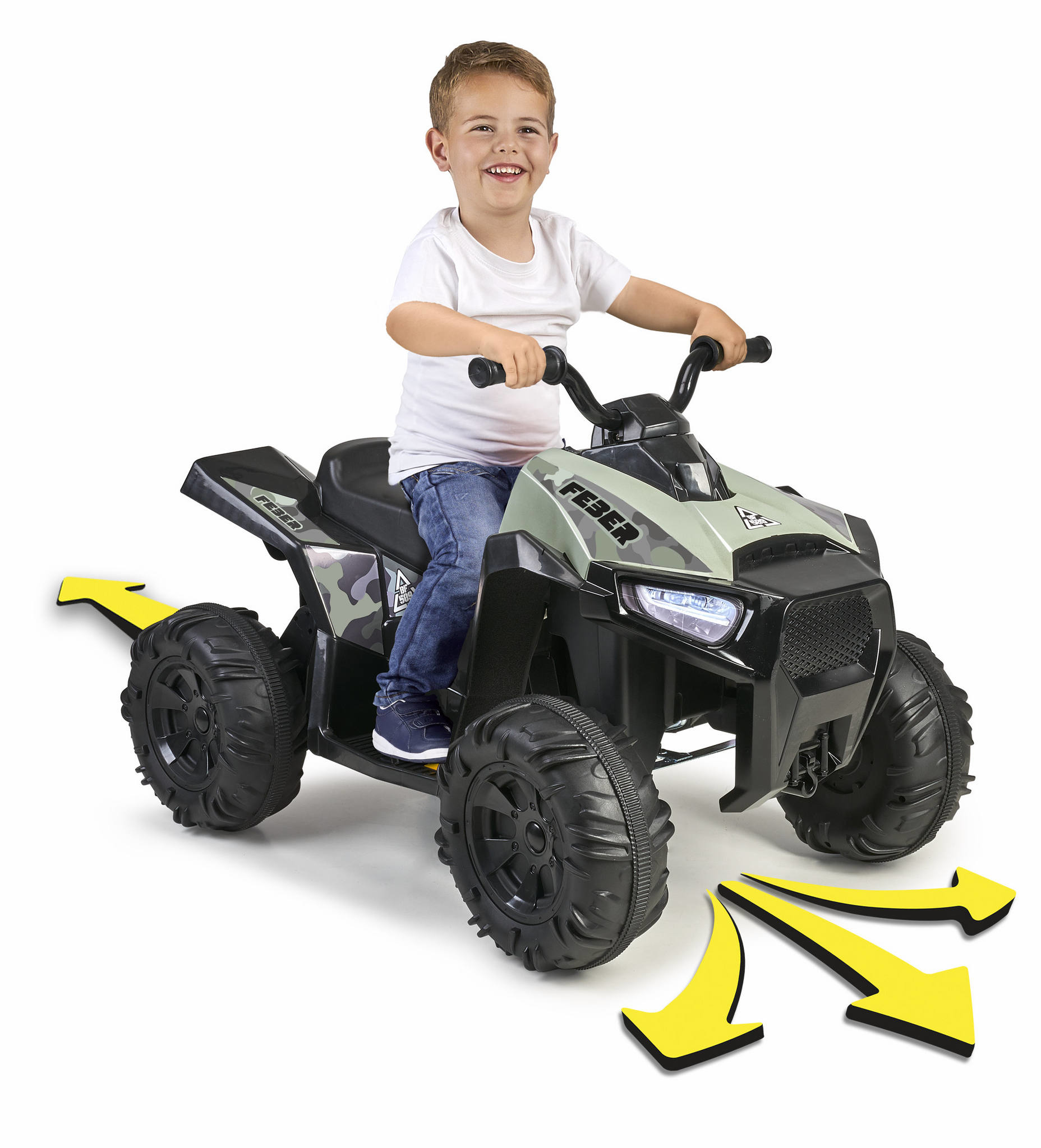 Un niño monta un quad de juguete, con flechas amarillas. El quad es negro y verde. El niño está sonriendo.