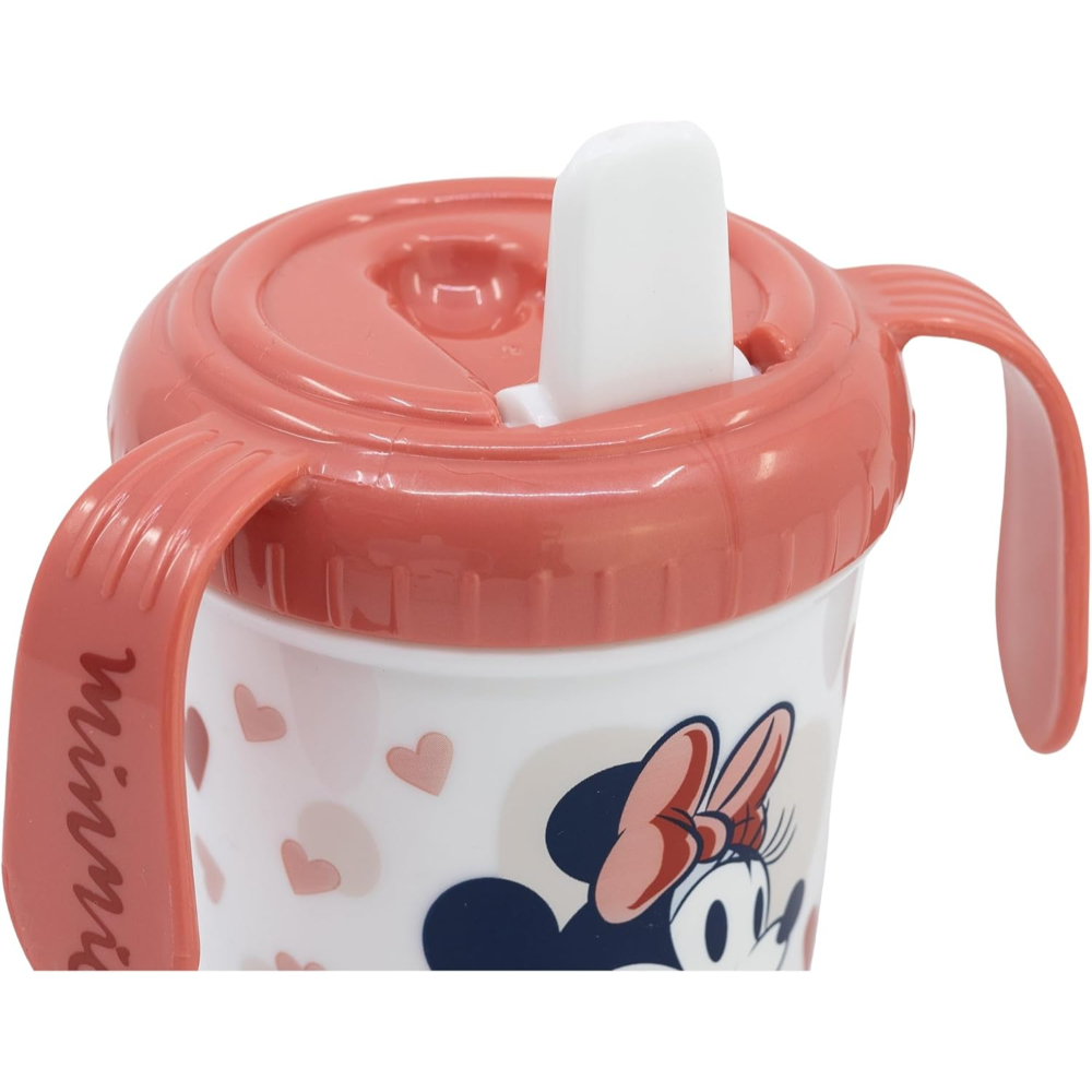 Un vaso para sorber de Minnie Mouse. Tapa y asa rosas. La cara de Minnie y corazones decoran el vaso blanco.