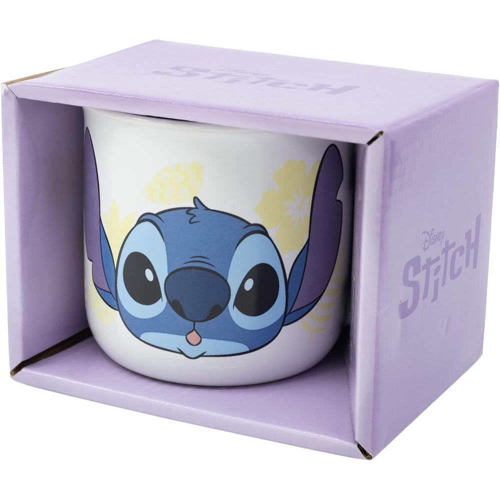Una taza de Stitch en una caja. La taza tiene una cara azul de Stitch y flores amarillas.