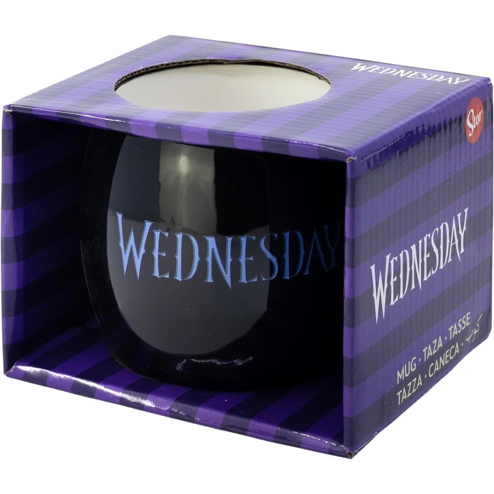 Una taza negra en una caja con la palabra "WEDNESDAY". La caja es morada y negra.