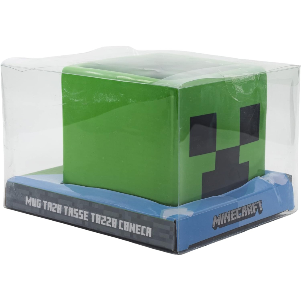 Taza Creeper de Minecraft verde en caja. La caja es de plástico transparente. Taza verde con cara Creeper negra.