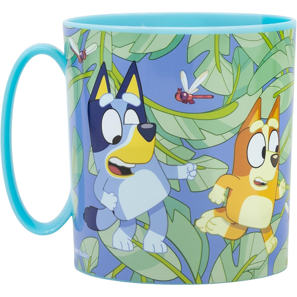 Una taza con los personajes de Bluey y Bingo, un asa azul y un fondo de jungla.