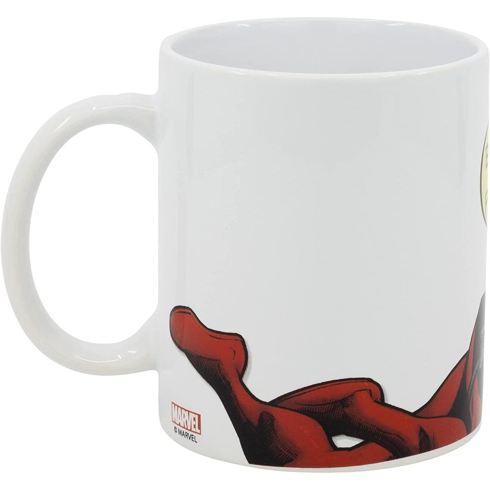 Taza blanca con diseño de Spiderman. El asa está a la izquierda. Detalles rojos y negros en la base.
