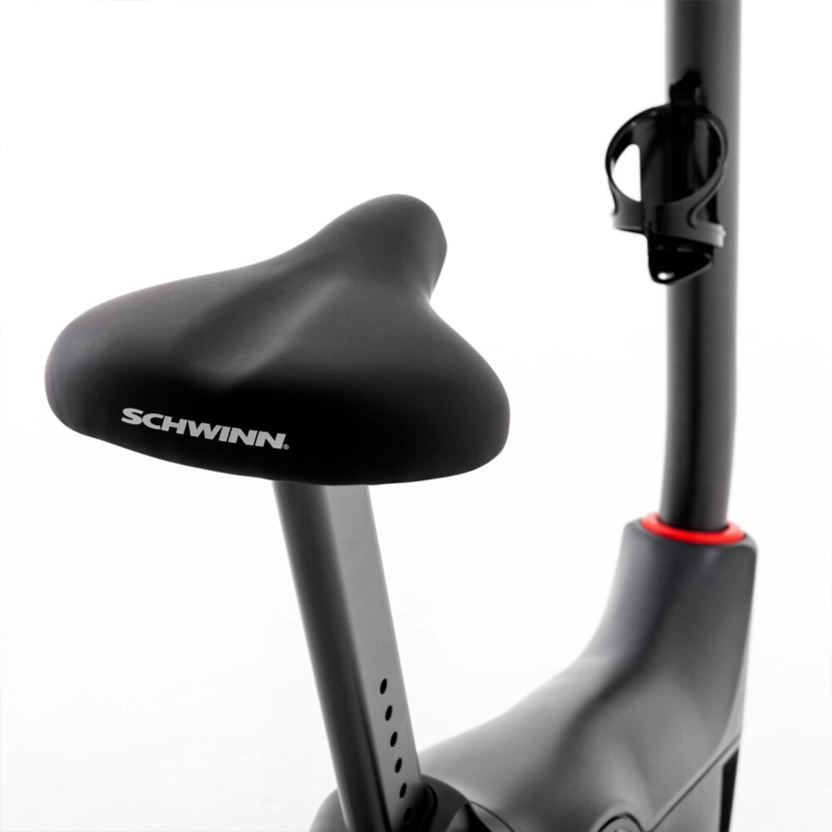 Selle et tige de vélo d'exercice Schwinn noirs. Accent rouge sur la tige visible. Isolé sur blanc.