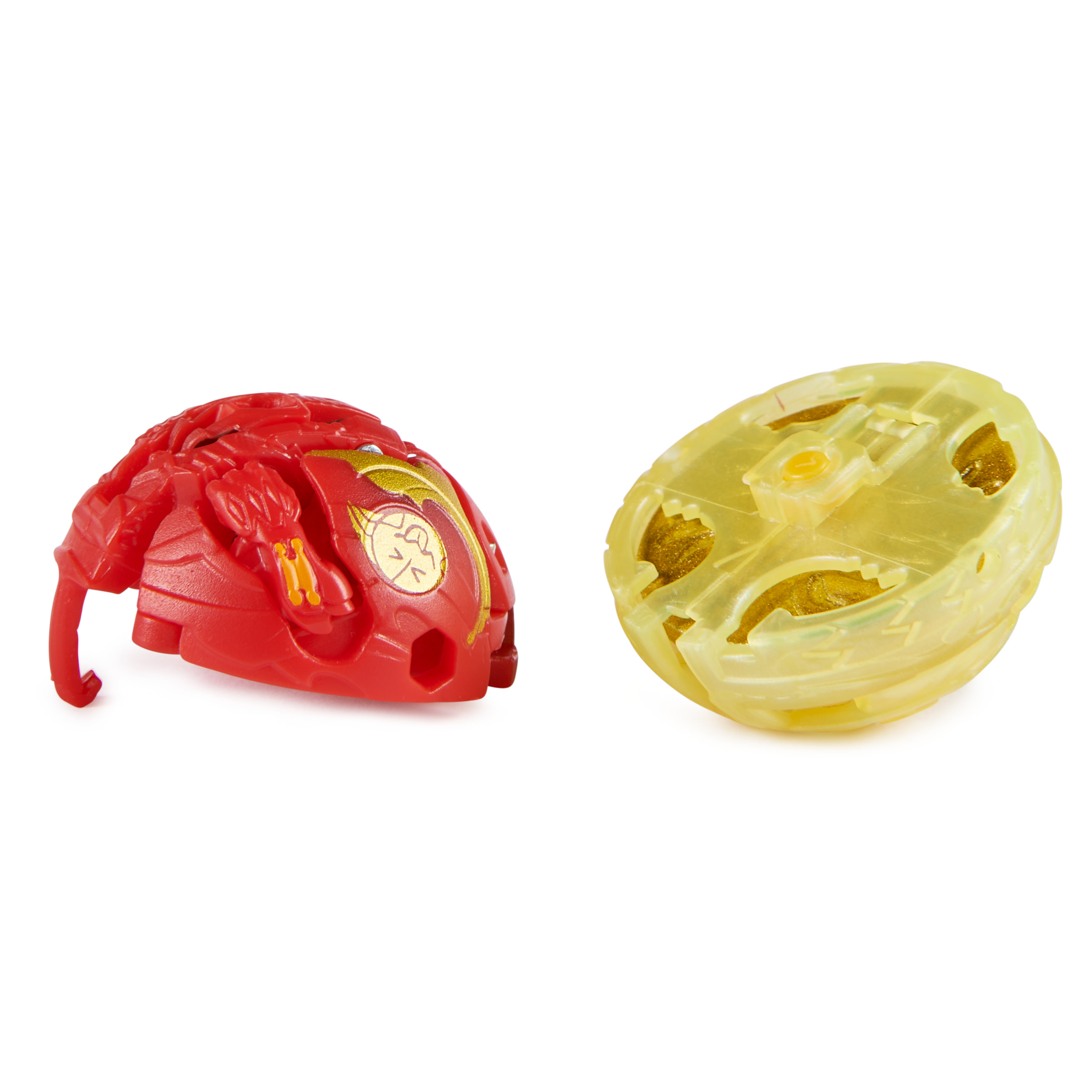 Dos juguetes Bakugan, uno rojo y otro amarillo, en forma de bola y abierta, sobre una superficie blanca.
