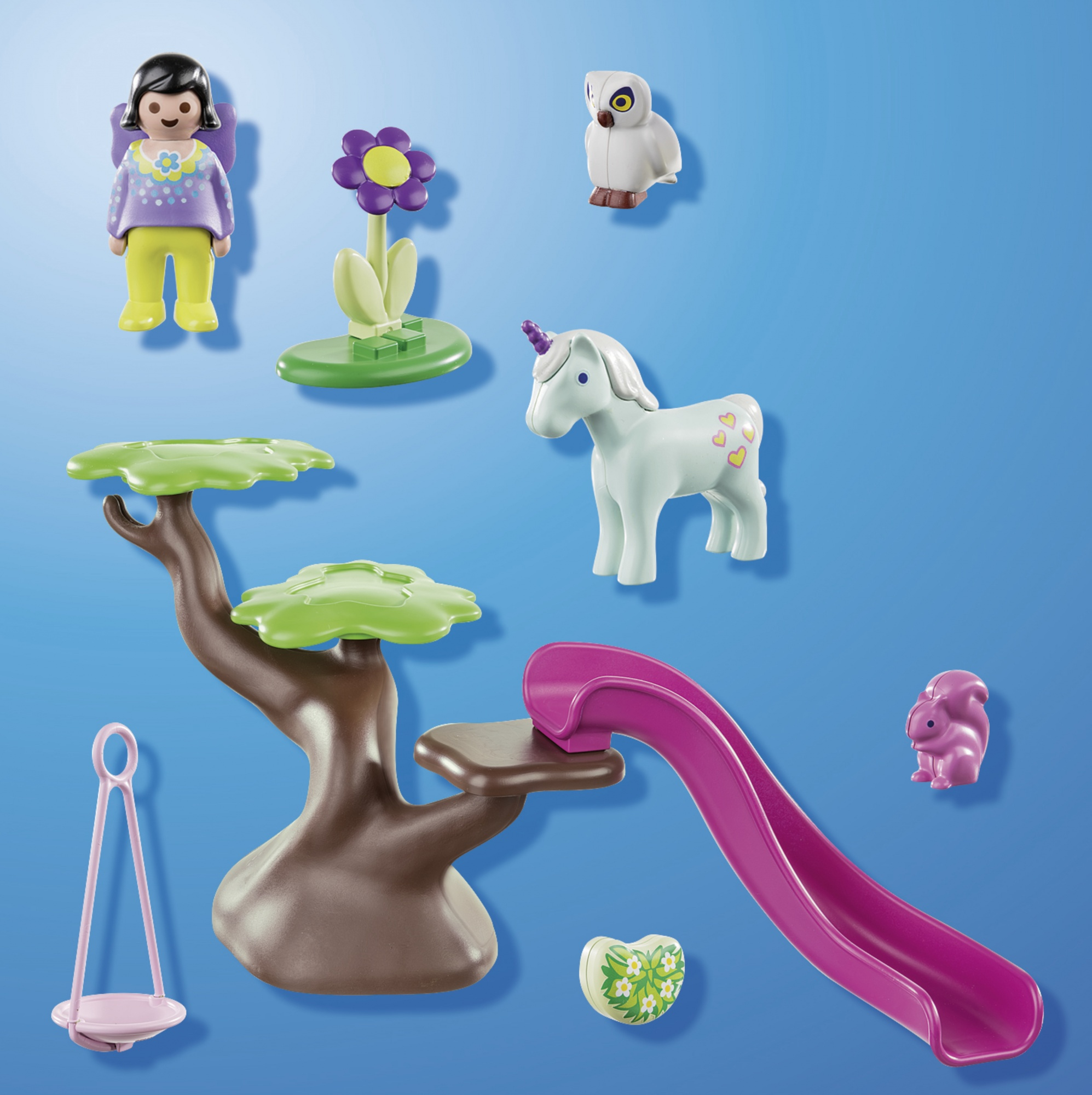 Personaggi e accessori Playmobil, tra cui uno scivolo, un albero, un unicorno e un fiore.