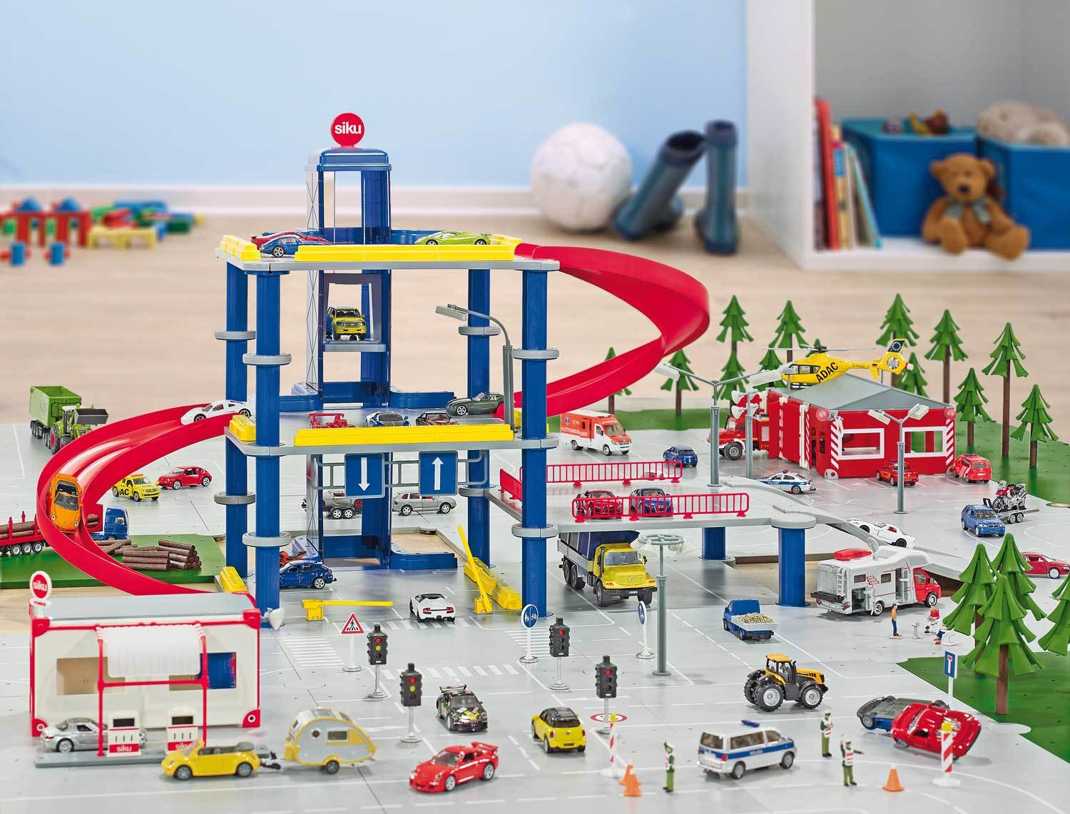 Eine Spielzeug-Parkgarage mit Autos und Figuren. Der Hintergrund ist eine Spielzimmerumgebung.