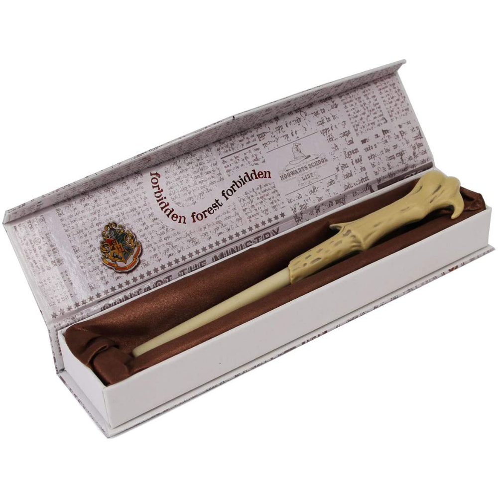 Varita de Harry Potter en una caja. La caja tiene escritura y la varita es beige.