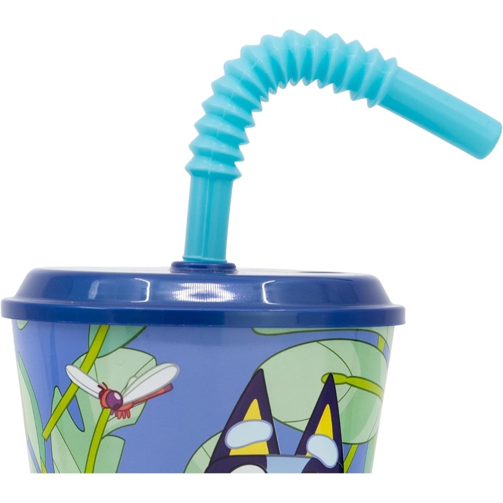 Vaso azul con personajes de dibujos animados de Bluey y una pajita azul. Fondo verde.