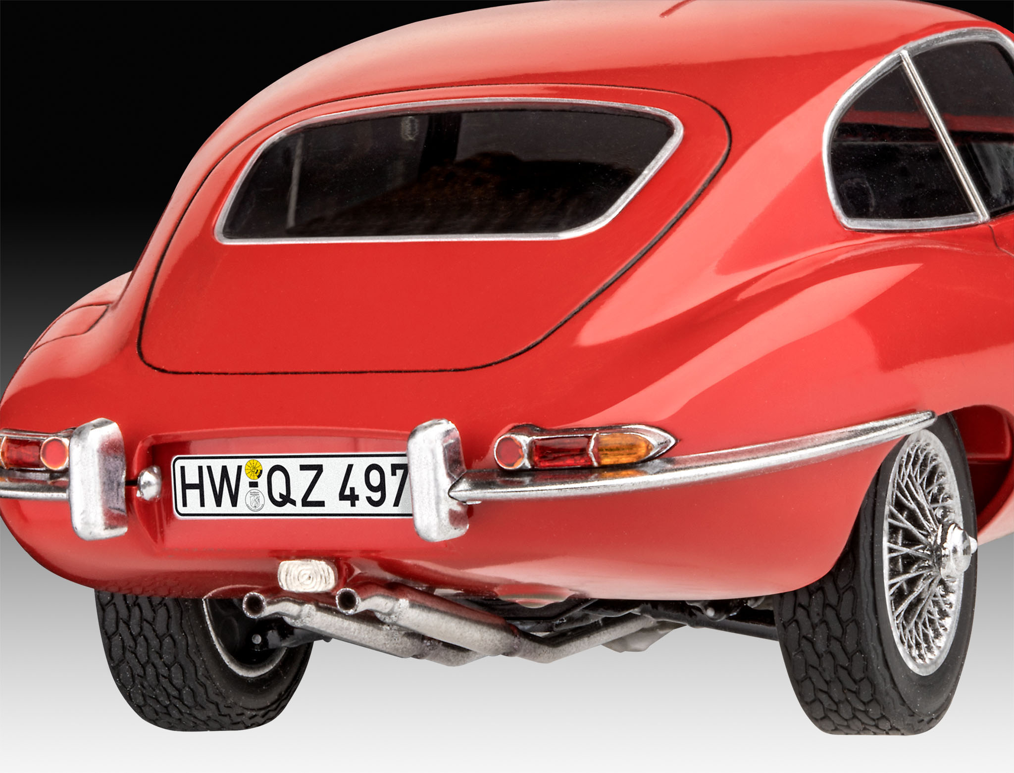 Rückansicht eines roten Oldtimers mit Kennzeichen. Rückleuchten und Chrom sind sichtbar.