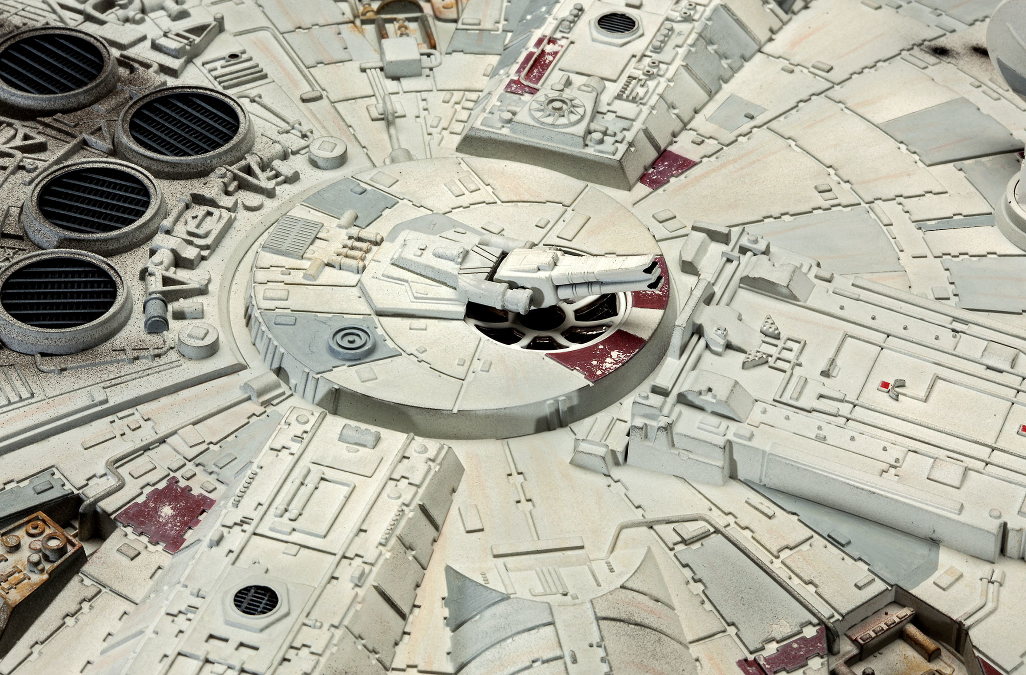 Een gedetailleerd beeld van het Millennium Falcon ruimteschipmodel, met grijze en rode details op het oppervlak.