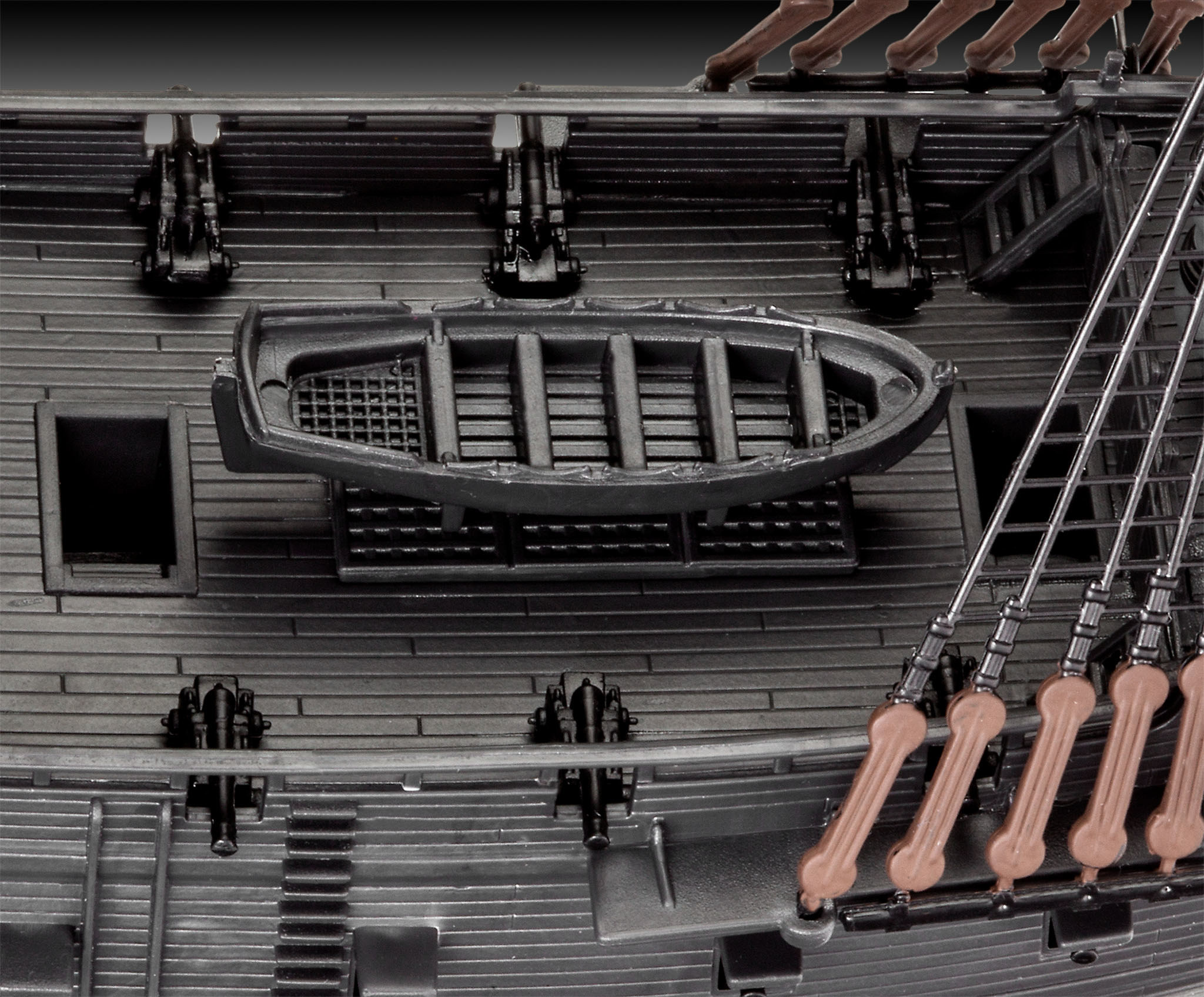 Dettaglio del modello di nave che mostra il ponte, i cannoni e una piccola barca.