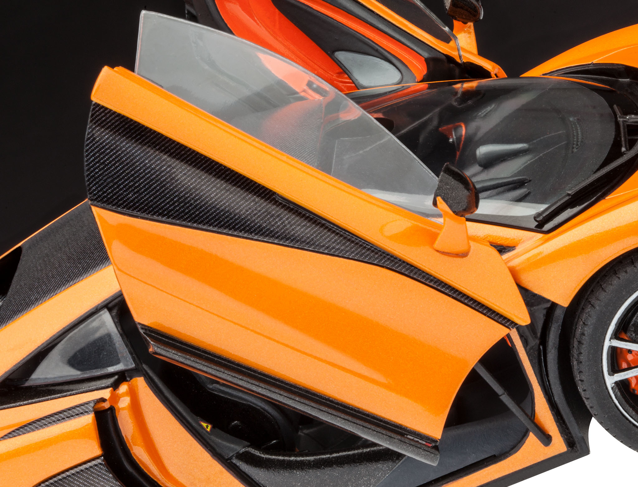 Nahaufnahme eines orangefarbenen Sportwagens mit geöffneter Tür, der Kohlefaserdetails zeigt.