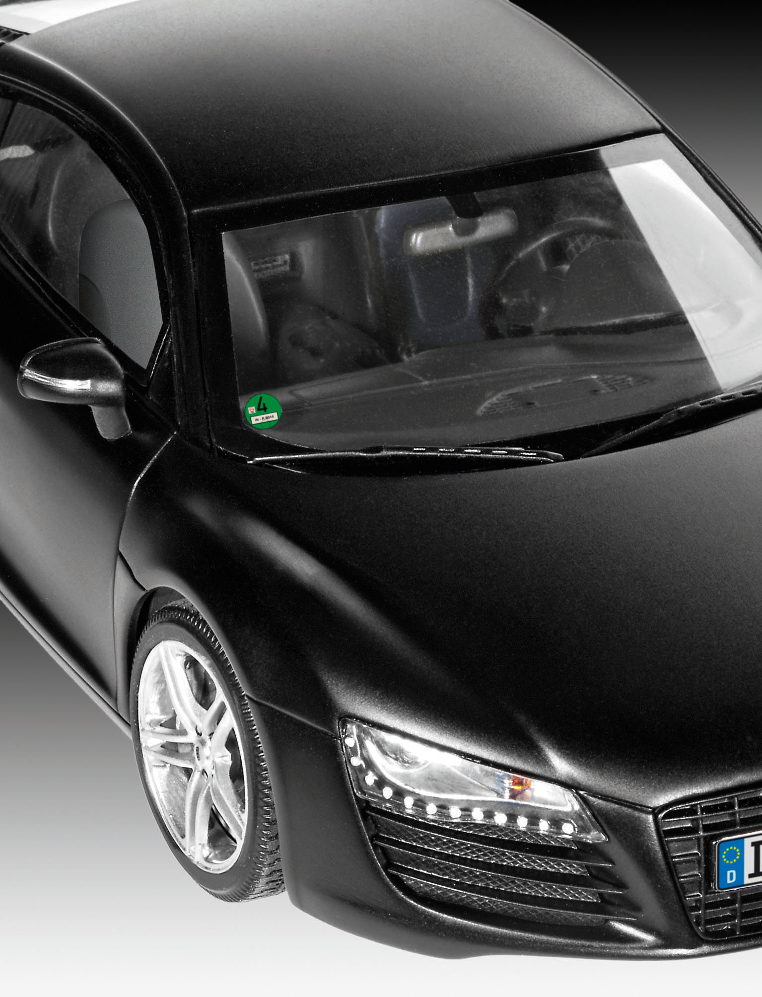 Czarny model samochodu Audi R8, widok z przodu, z widocznymi reflektorami i tablicą rejestracyjną.