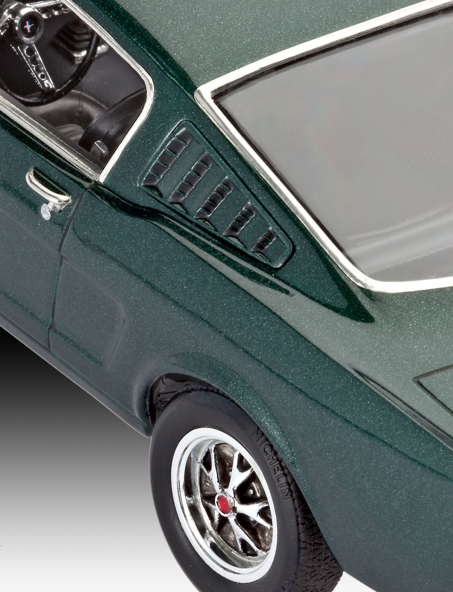 Close-up van een klassieke groene auto. Focus op het zijpaneel, de band en de chromen details.