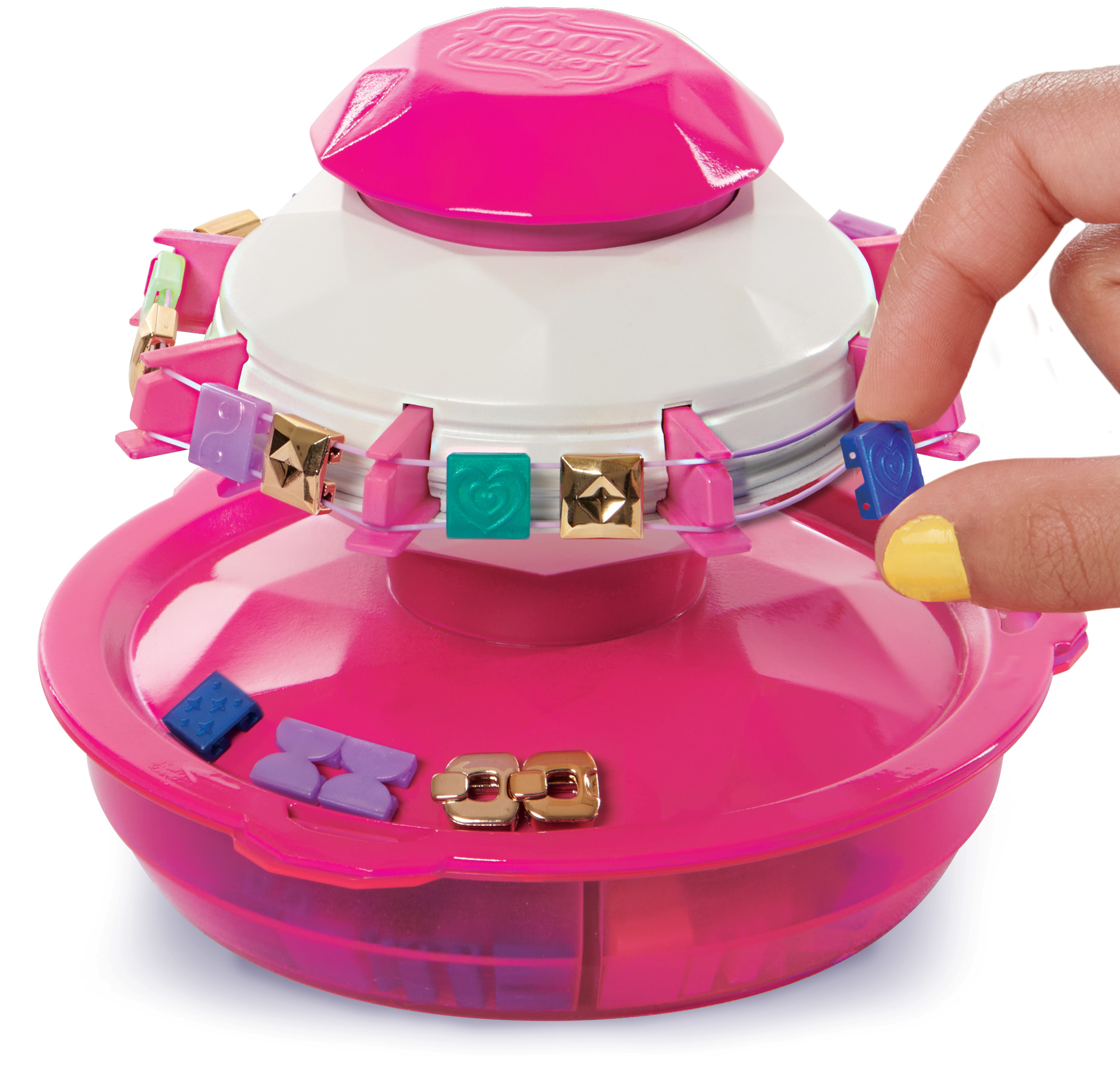La mano de una persona coloca una joya cuadrada en una máquina de manualidades rosa y blanca.
