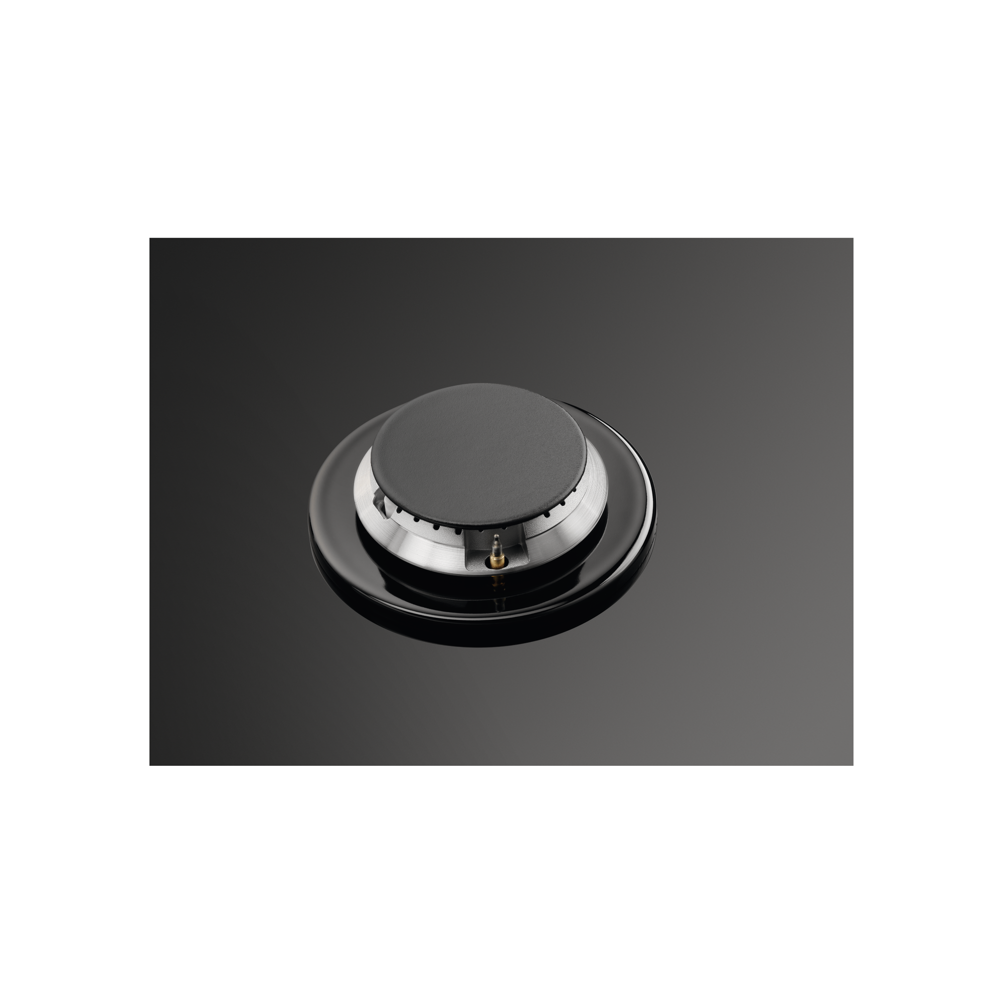 Czarny palnik kuchenki. Okrągły z czarną powierzchnią i srebrnym pierścieniem. Powierzchnia odbijająca światło.