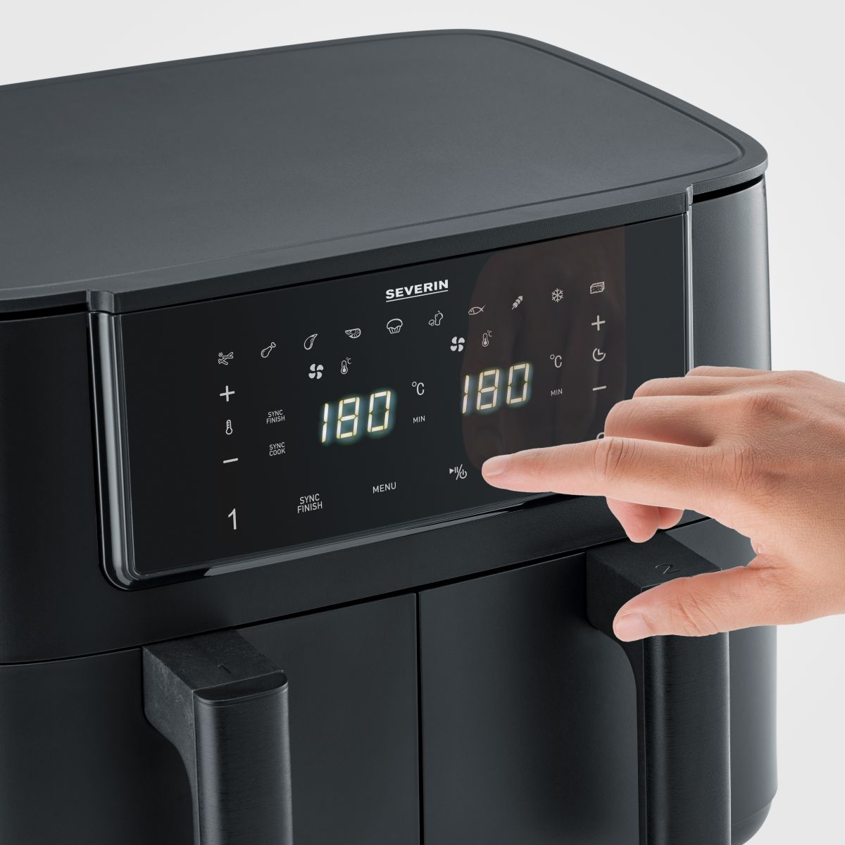 Czarna frytkownica powietrzna z cyfrowym wyświetlaczem. Ręka dotyka ekranu.