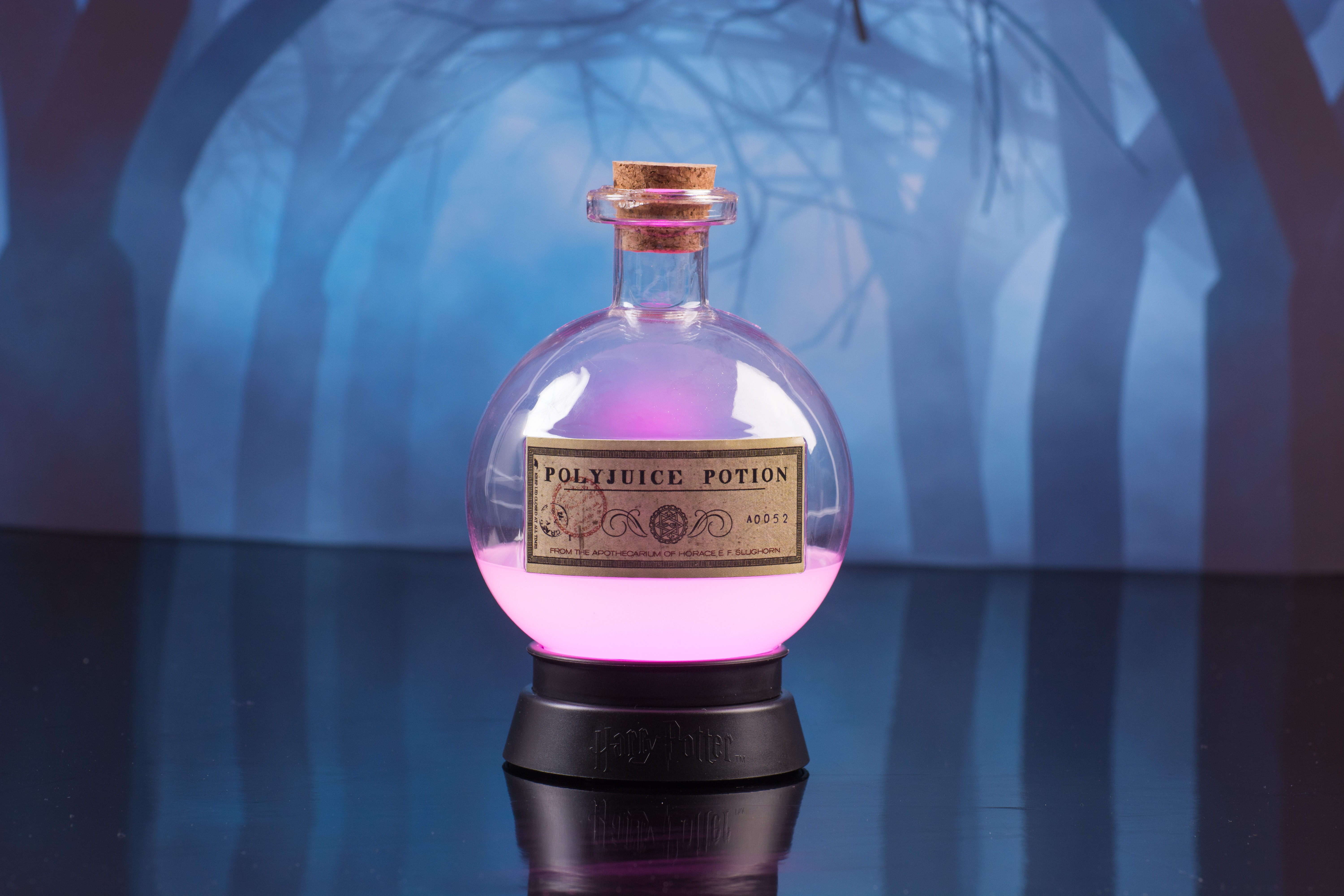 Harry Potter's Felix Felicis fles met roze licht, op een standaard. Achtergrond is een bosscène.