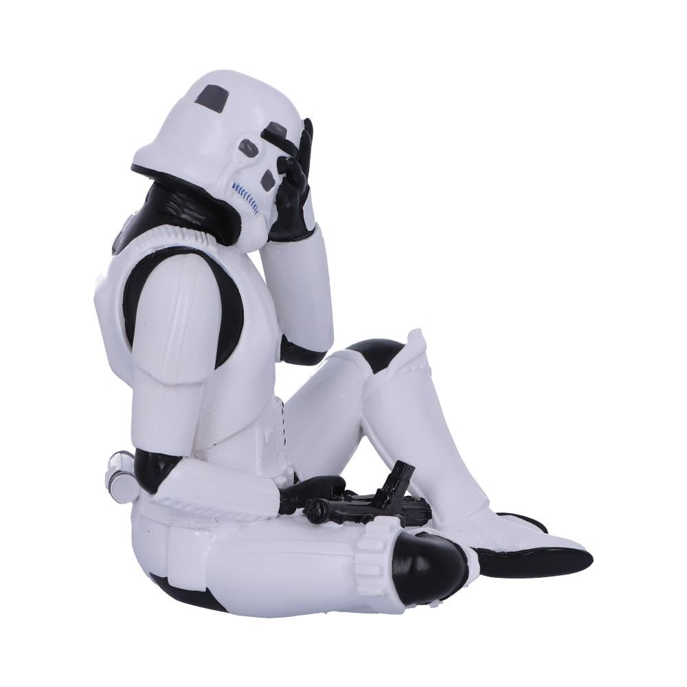 Stormtrooper-figuur, zittend, hand op gezicht. Witte harnas met zwarte accenten. Zwart blastergeweer in de buurt.