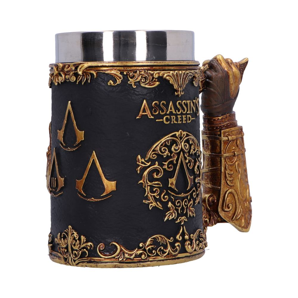 Assassin's Creed mok. Zwart met gouden accenten, een handvormig handvat en logo's.