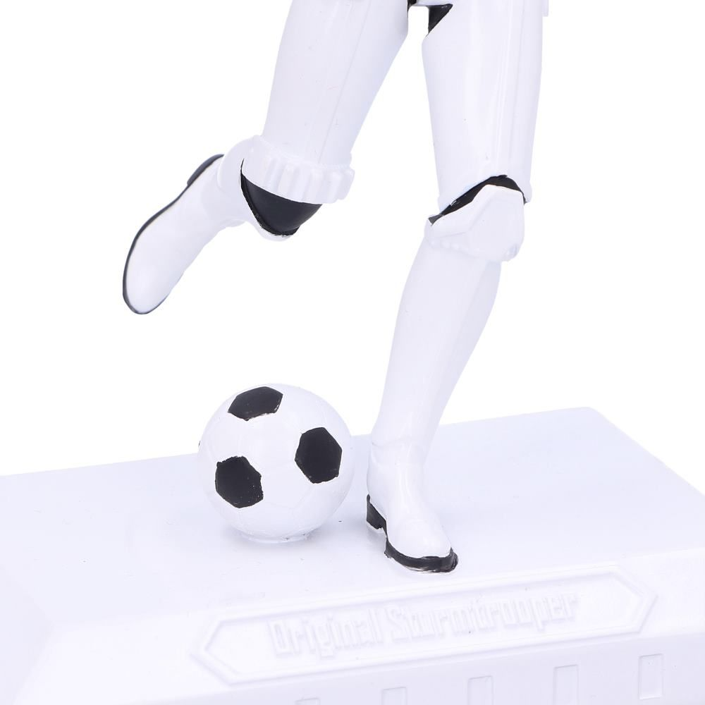 Een witte Star Wars Stormtrooper die tegen een voetbal trapt op een witte basis.
