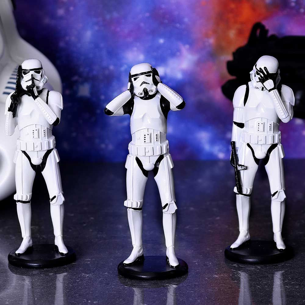 Drei weiße Stormtrooper-Figuren stehen da und bedecken Ohren und Augen.