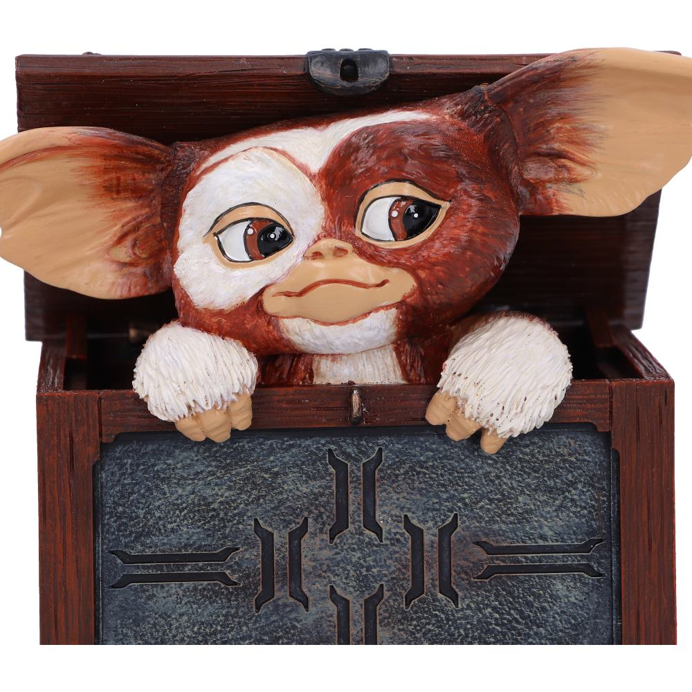 Gremlin figuur die uit een houten schatkist kijkt met een donkerblauw binnencompartiment.