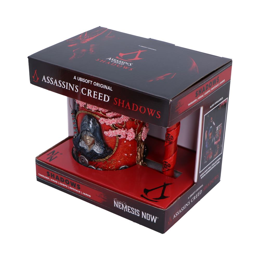 An Assassin's Creed Shadows mug inside a box. The mug is red and has a character portrait on it.