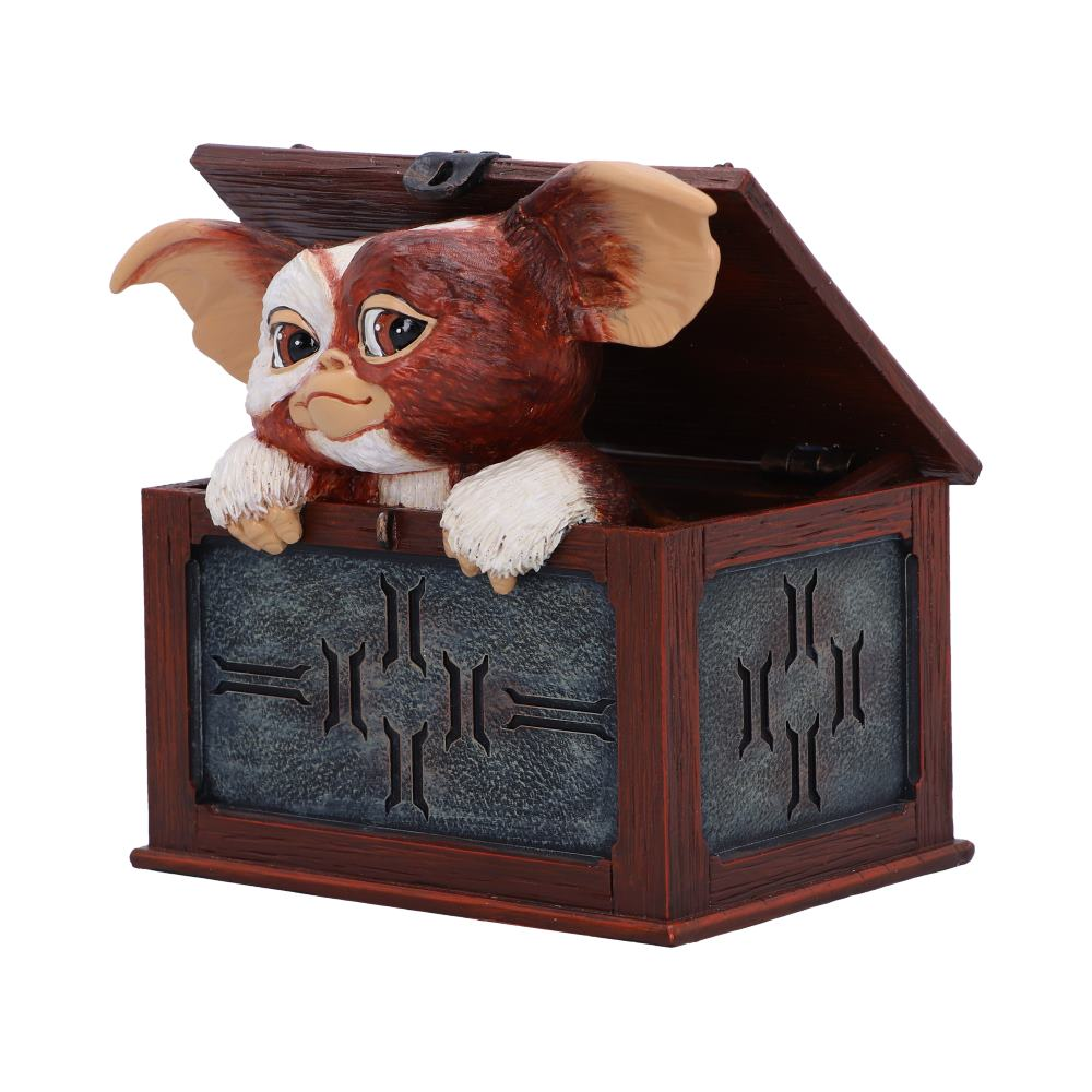 Gremlin beeldje in een schatkist, die naar buiten gluurt. Bruine en blauwe kleuren.