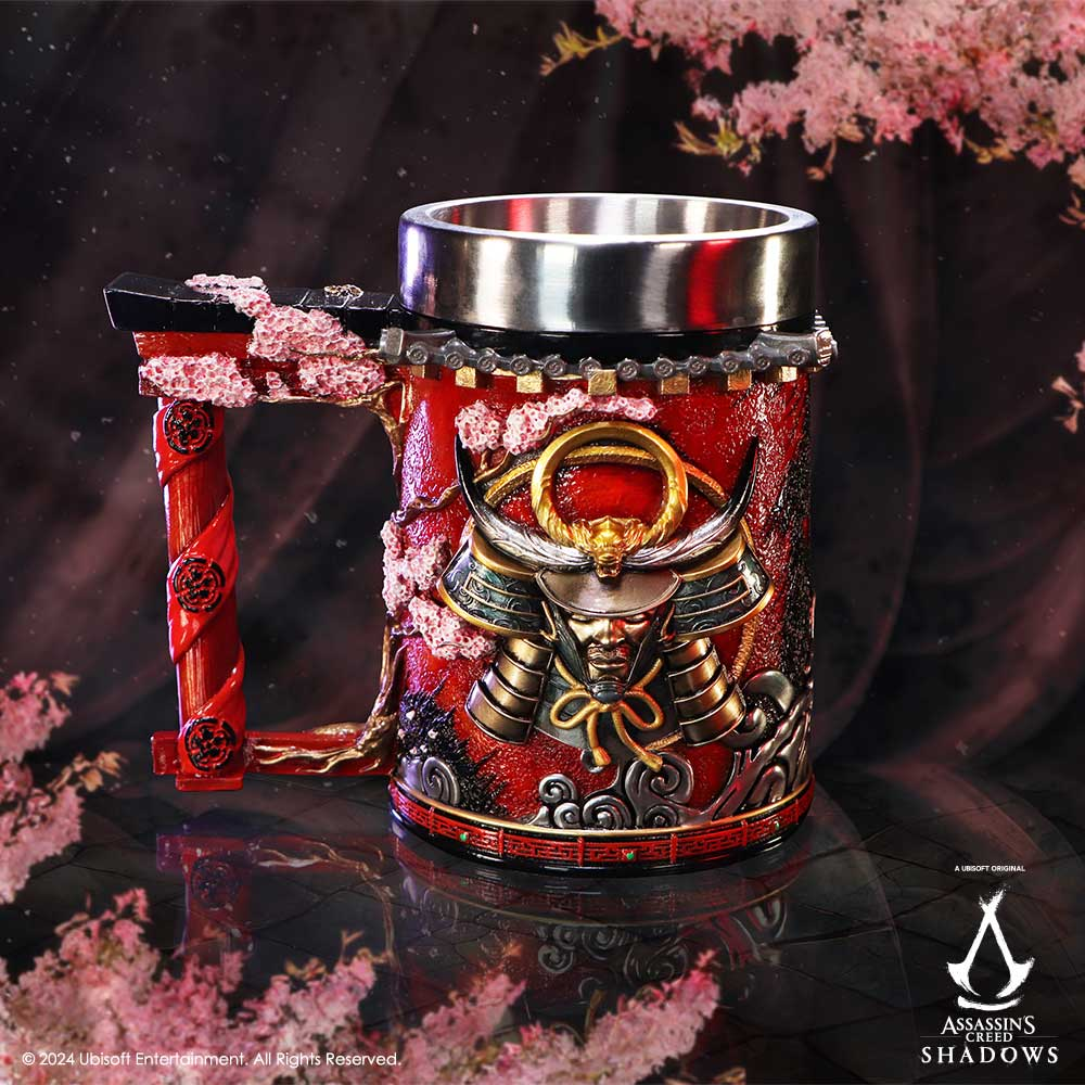 A ceramic mug with an Assassin's Creed theme. The mug has a handle and artwork. The background is dark.