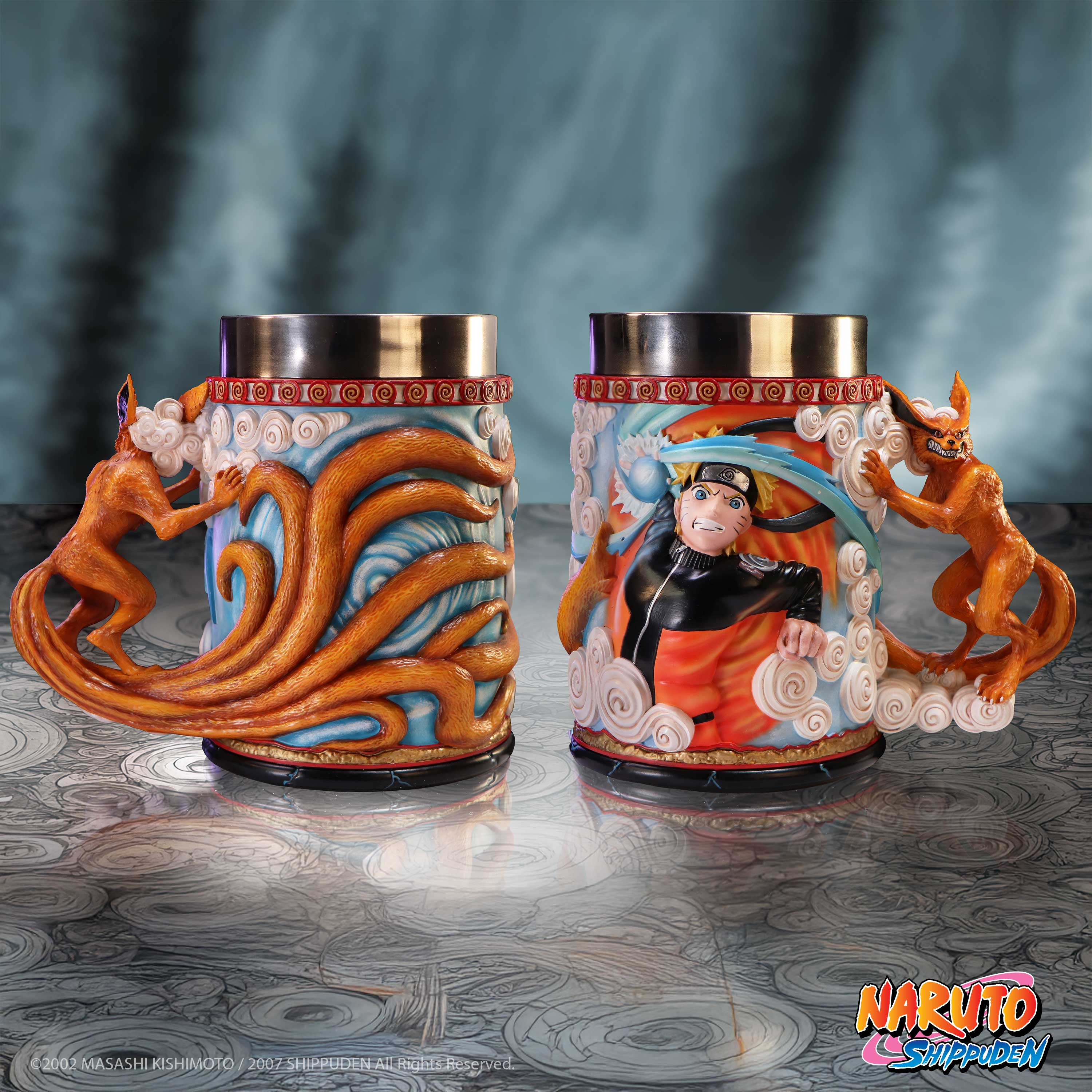 Twee Naruto-mokken. Eén met Naruto en Kyuubi, de andere met de staart van Kyuubi. Achtergrond blauw.