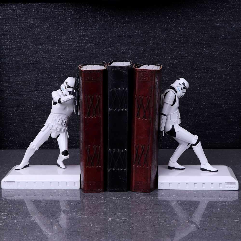 Stormtrooper boekensteunen die boeken vasthouden op een oppervlak, een donkere achtergrond.