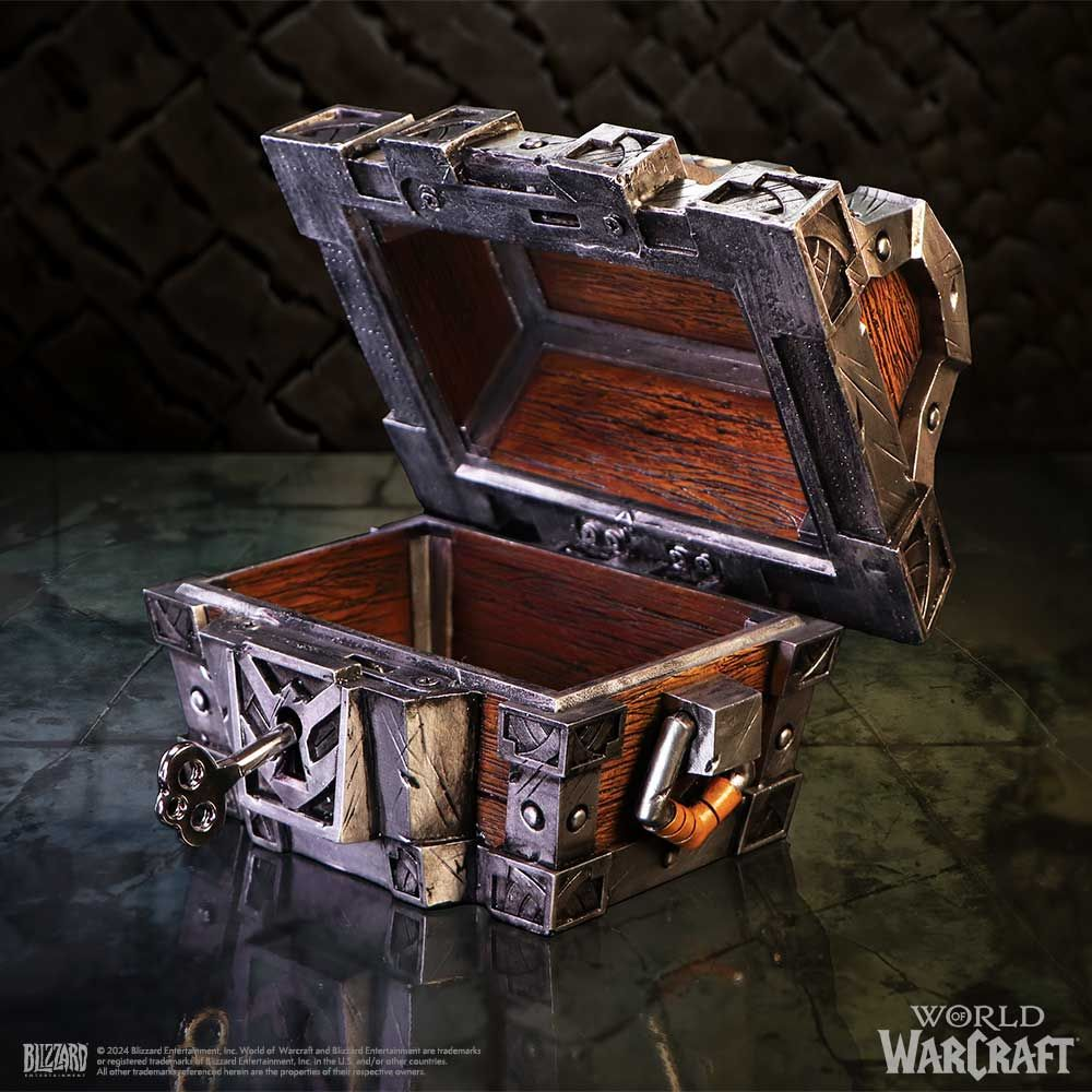 Een World of Warcraft schatkist, open, met sleutel, in een zwak verlichte stenen kamer. Metalen details.