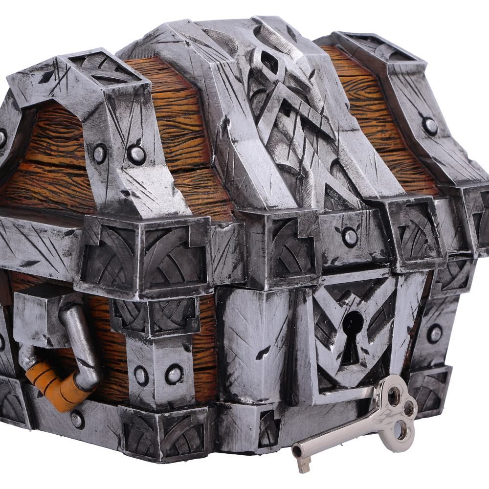 Een antieke houten kist met zilveren metalen details, een sleutel ligt ervoor.